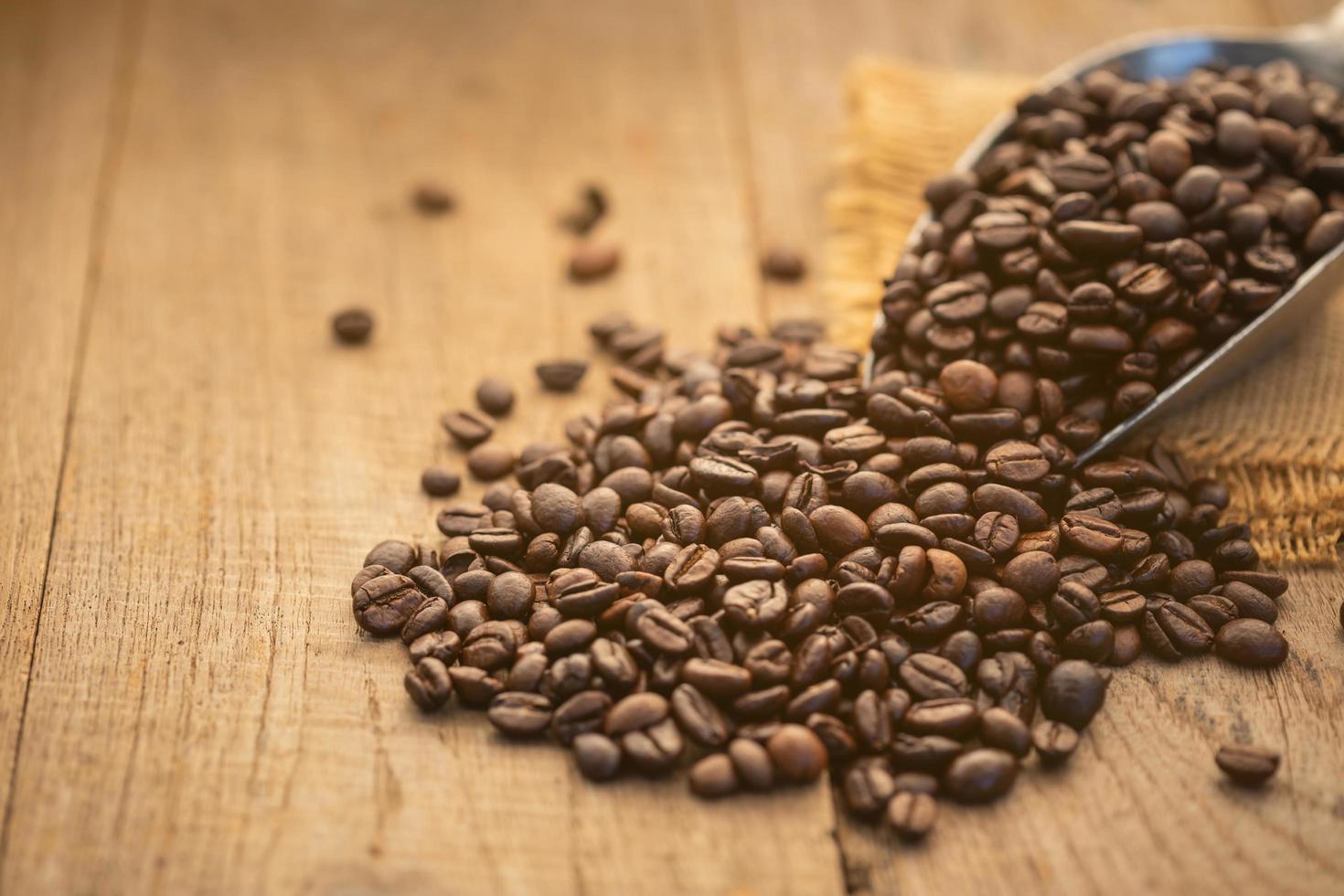 grano de café sobre fondo de mesa de madera. concepto de alimentos y bebidas foto