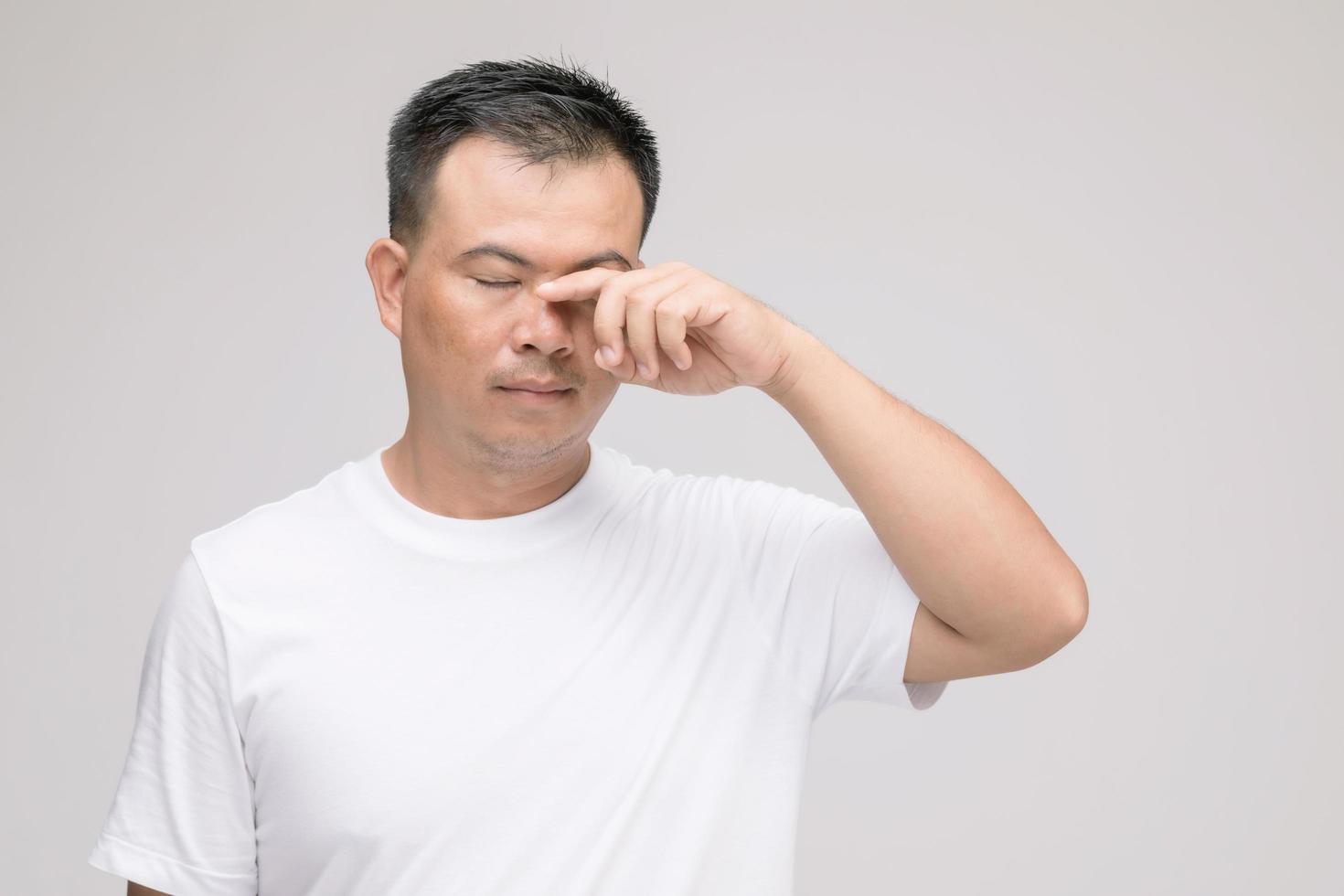 Eye irritation concept, Portrait of Asian man in posture of eye tired,  irritation or problem about his eye. Studio shot isolated on grey photo