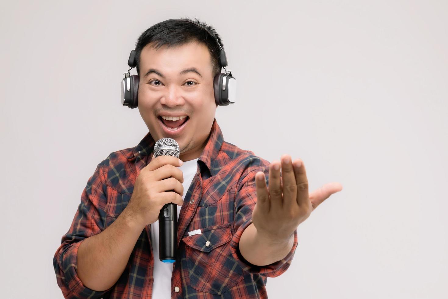 Portrait Asian man listening song or music from black headphone. Studio shot isolated on grey photo