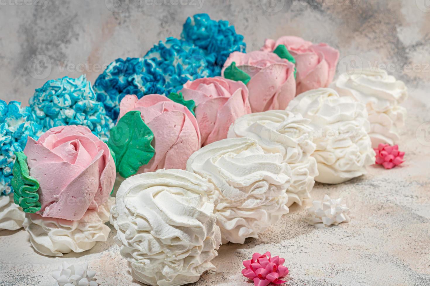 Handmade marshmallows on a light background in the form of roses, hydrangeas and tulips. There are flowers nearby. Women's day, Valentine's day. photo
