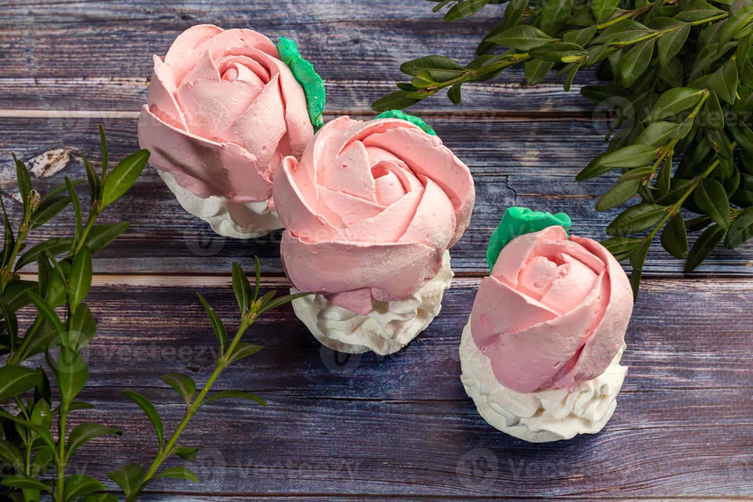 Handmade marshmallows on a light background in the form of roses, hydrangeas and tulips. There are flowers nearby. Women's day, Valentine's day. photo