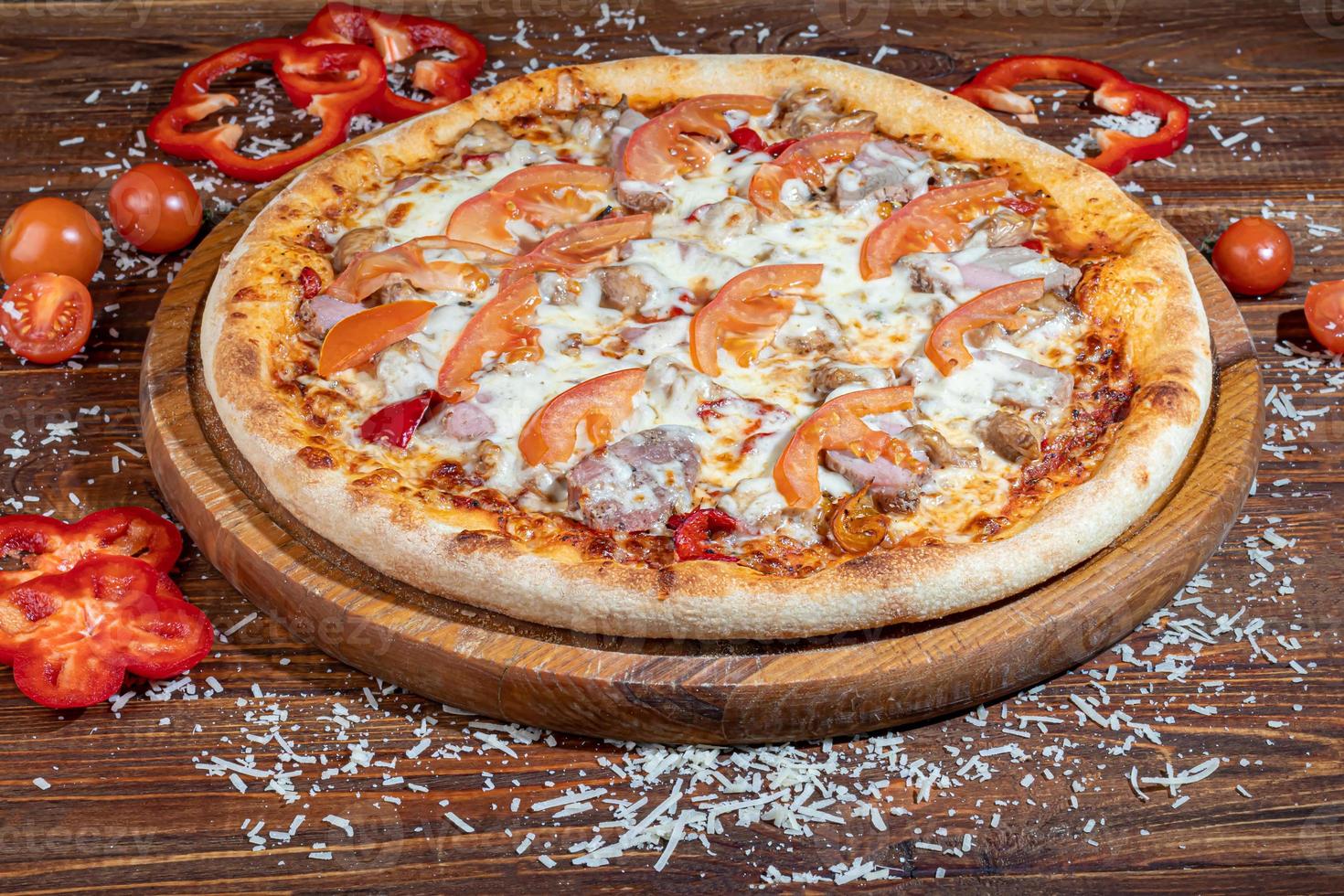 Pizza with bacon and cheese, herbs and cherry tomatoes. With mozzarella, shrimps and octopuses, mussels and other products on a wooden background. photo