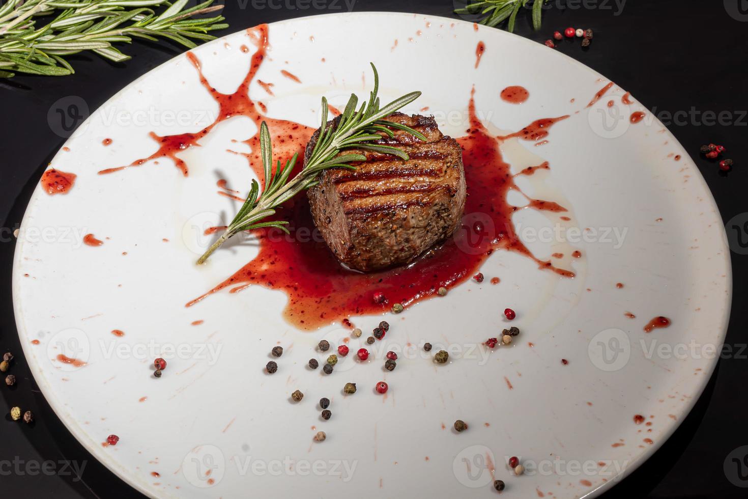 Meat dish on a plate with sauce. Chicken breast, fried pork. Parsley. Mustard sauces and ketchup. On a dark background. photo