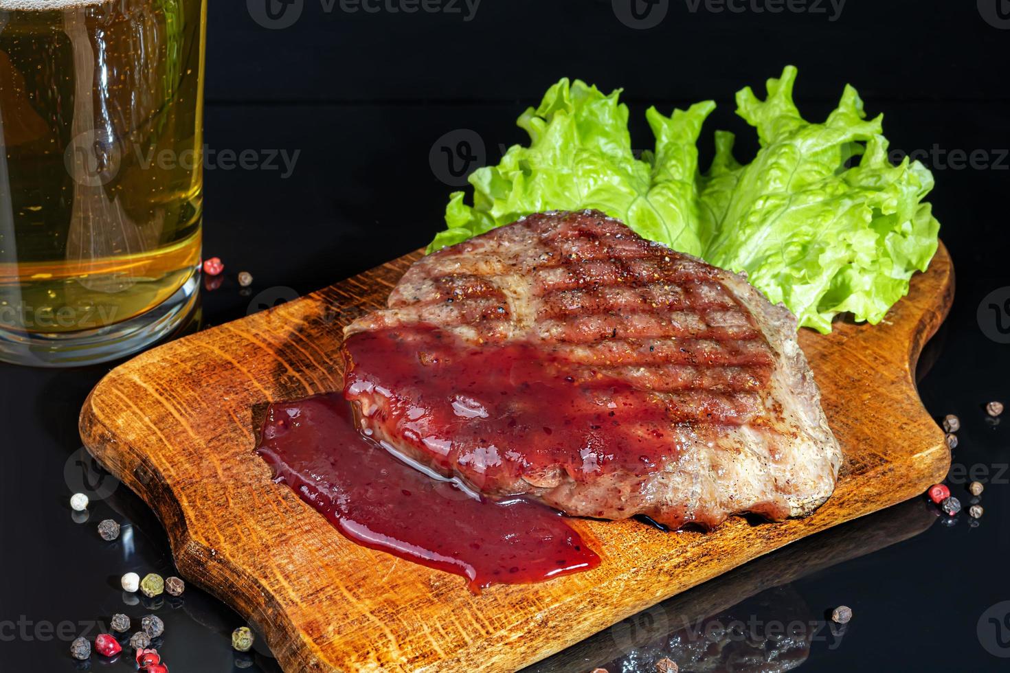 Meat dish on a plate with sauce. Chicken breast, fried pork. Parsley. Mustard sauces and ketchup. On a dark background. photo