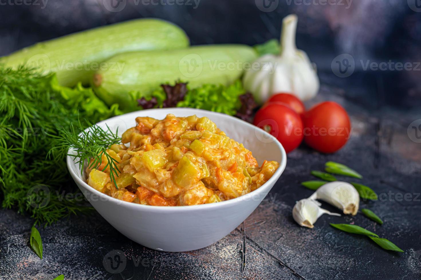 Caviar from zucchini, carrots and onions. Spring food. Vegetarianism. Along with spring vegetables. On a dark background. photo