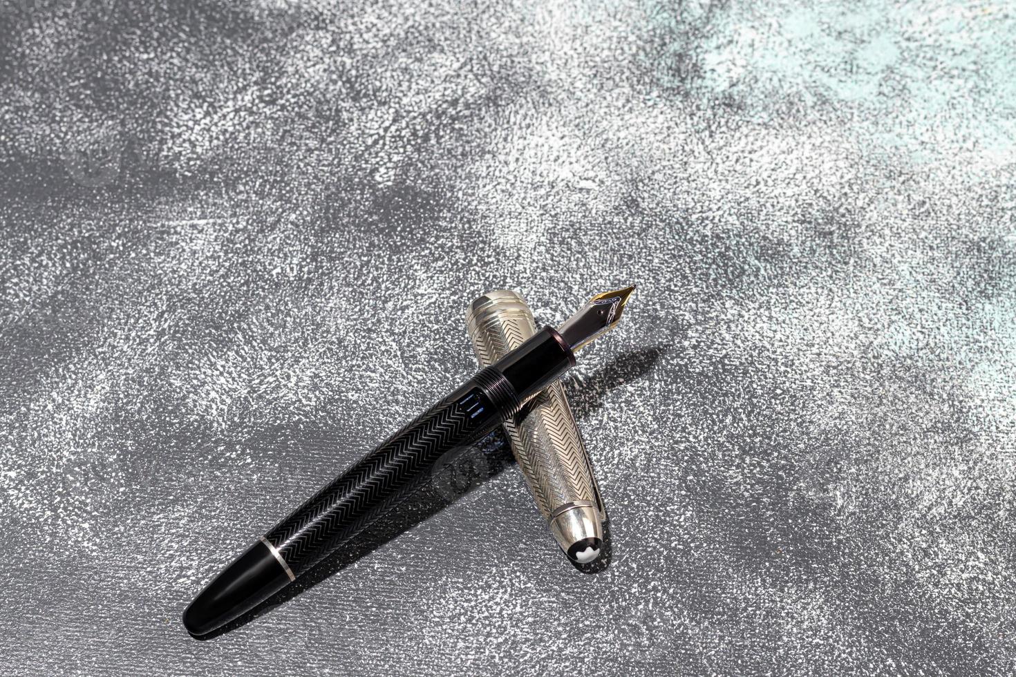 Fountain pen on a marble and gray background. Selective focus. photo