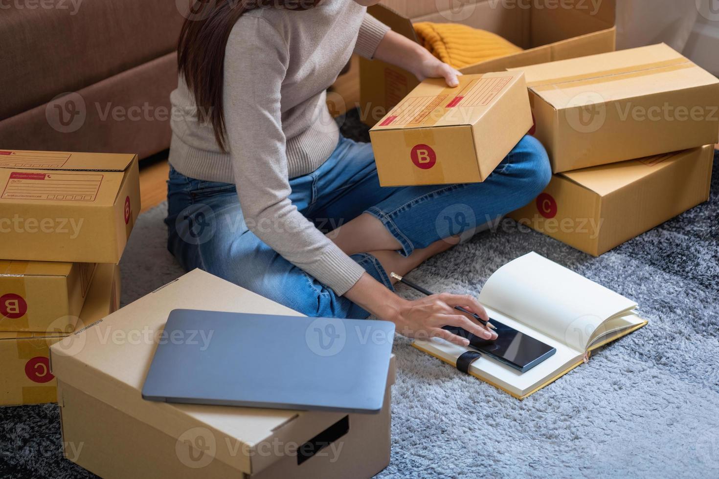 Young Asian SME businessman starting a small and boxed SME business as an online business. Online SME business concept. photo
