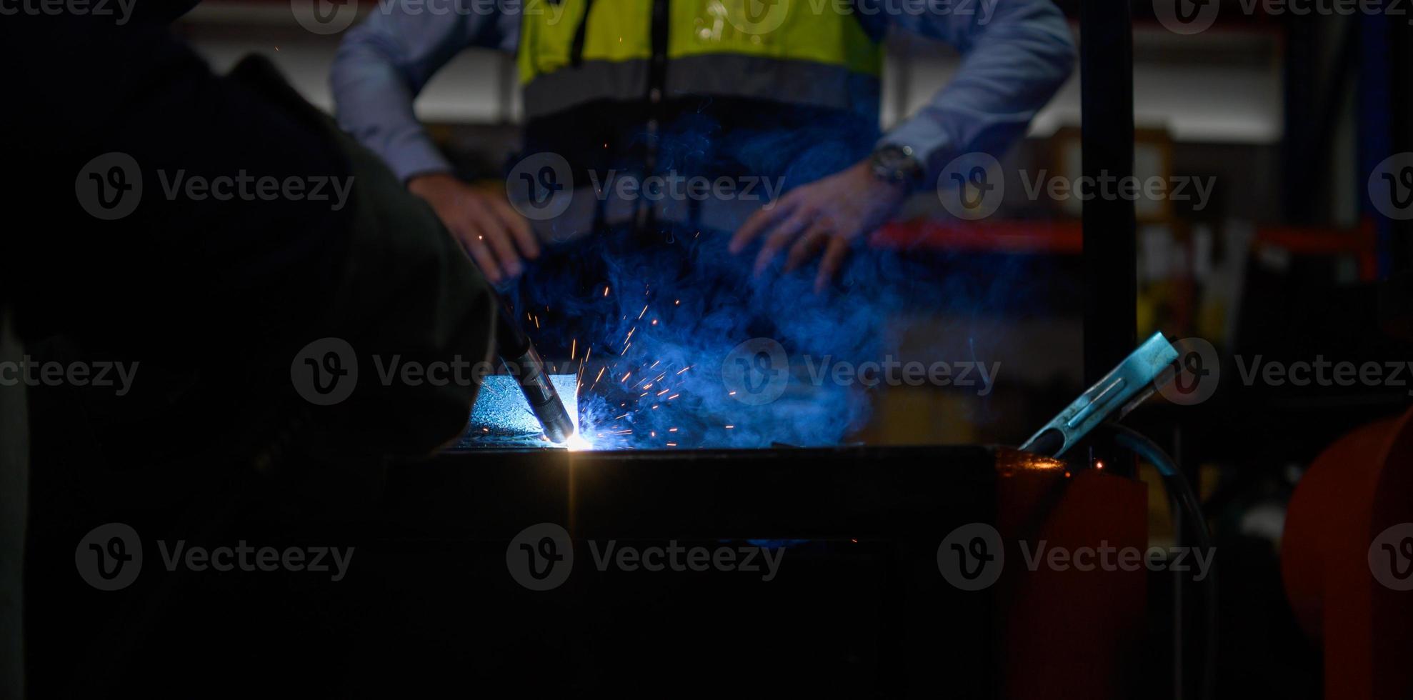Welder working welding metal with Engineer to closely control the work in order to obtain the quality according to the prescribed form. photo