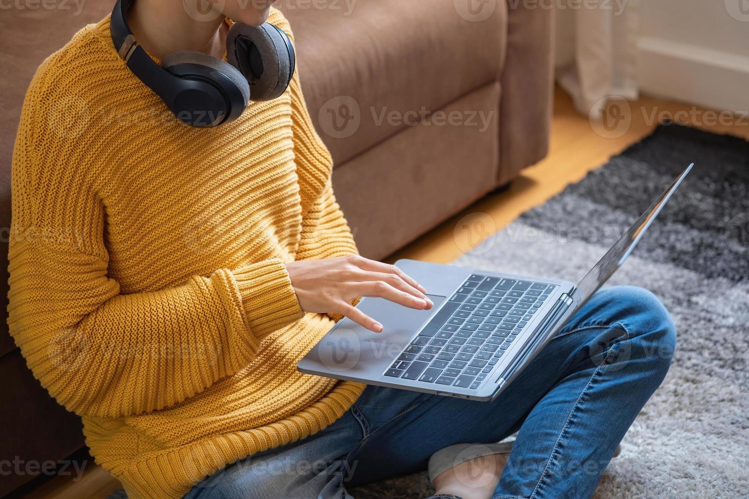relajarse, desestresarse, vacaciones, mujer asiática feliz relajándose en casa escuchando música desde un teléfono inteligente y una computadora portátil felizmente. foto