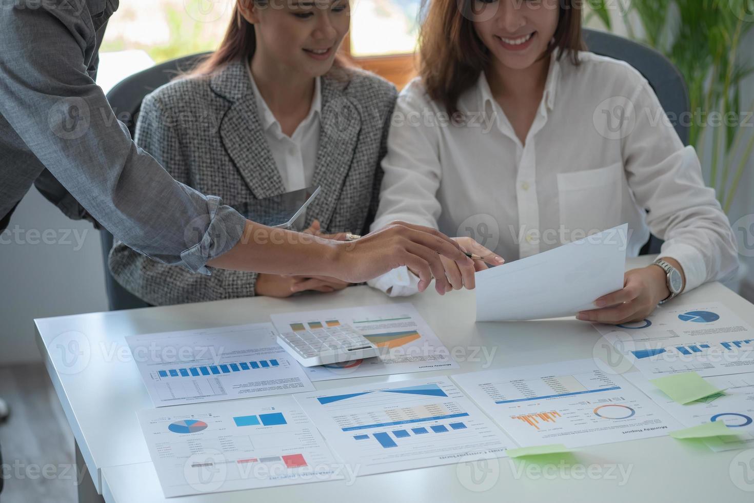 Team of business use calculators and graph analysis computer laptop tablets to plan marketing strategies and make profitable investments for the company. photo