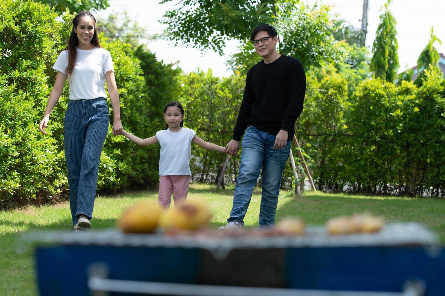 Family holiday activities include father, mother and children with camping barbecue and play in the yard together happily on vacation. photo