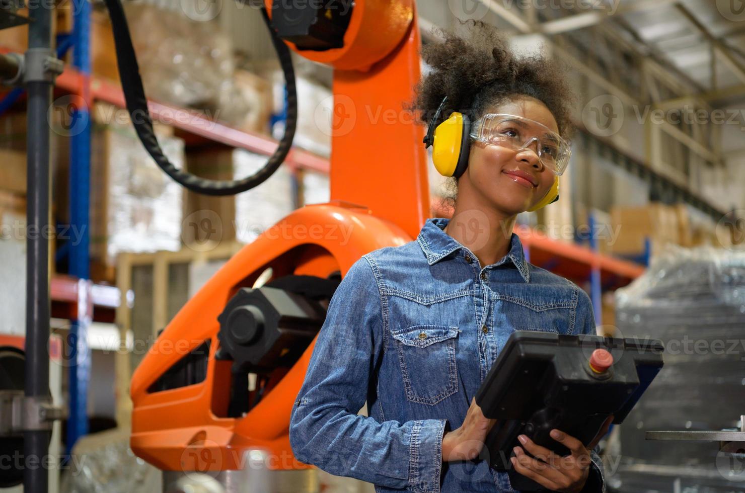 A young female worker is controlling a mechanical robot. to sort out the items that come into the warehouse to wait for the next shipment. photo