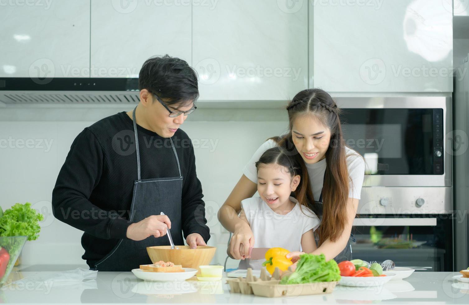 Asian family They are having cooking together happily in the kitchen room of the house. photo