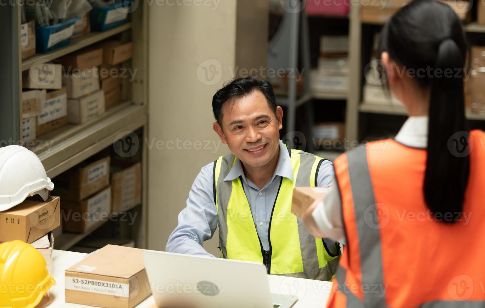 Warehouse Manager with female assistant Rethink a plan to prepare items that need to be sold to retailers during times of higher market prices. photo