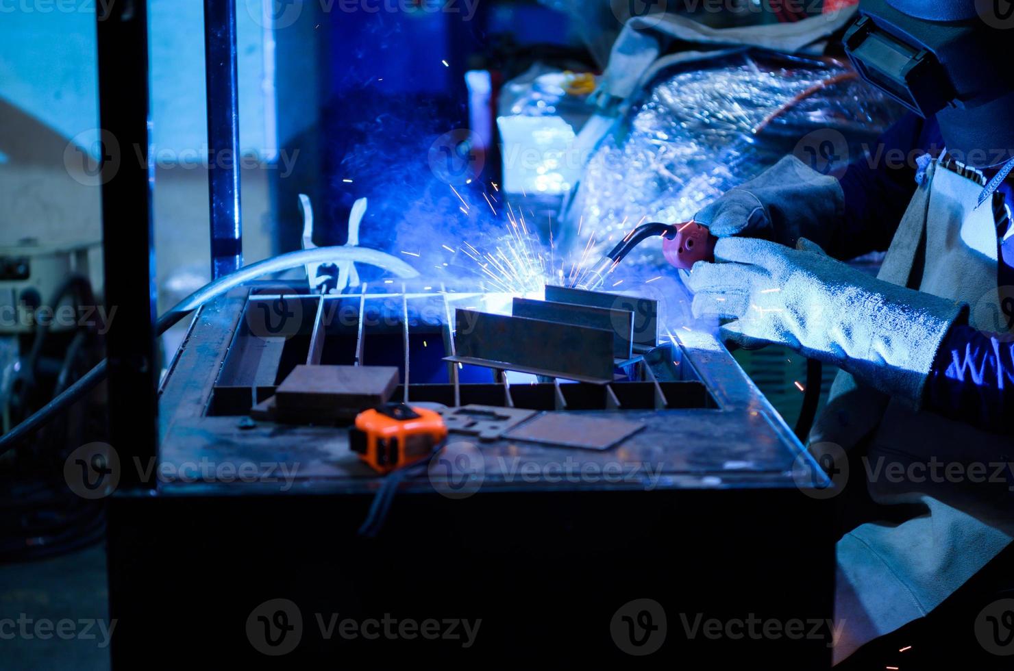 A welder is working to weld metal. to create quality work according to the prescribed form photo