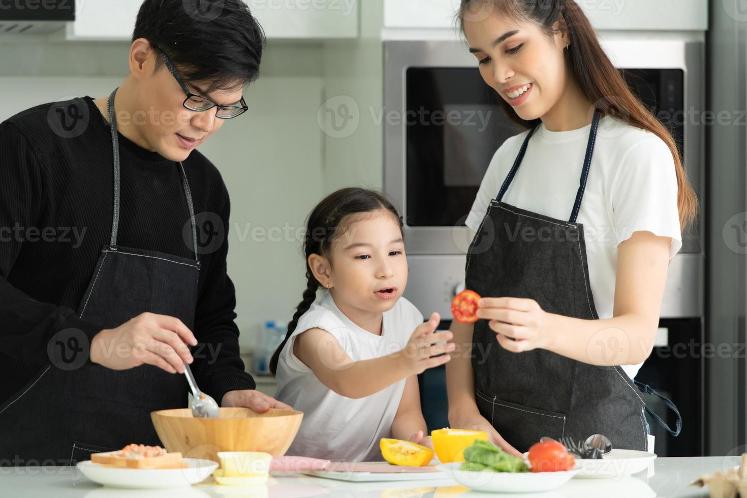 Asian family They are having cooking together happily in the kitchen room of the house. photo