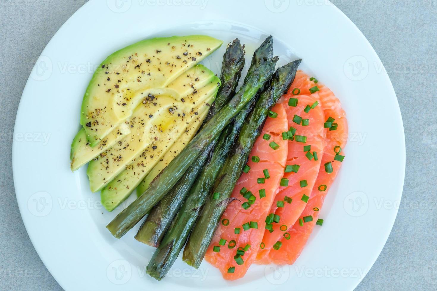 Plato de salmón, aguacate y espárragos foto