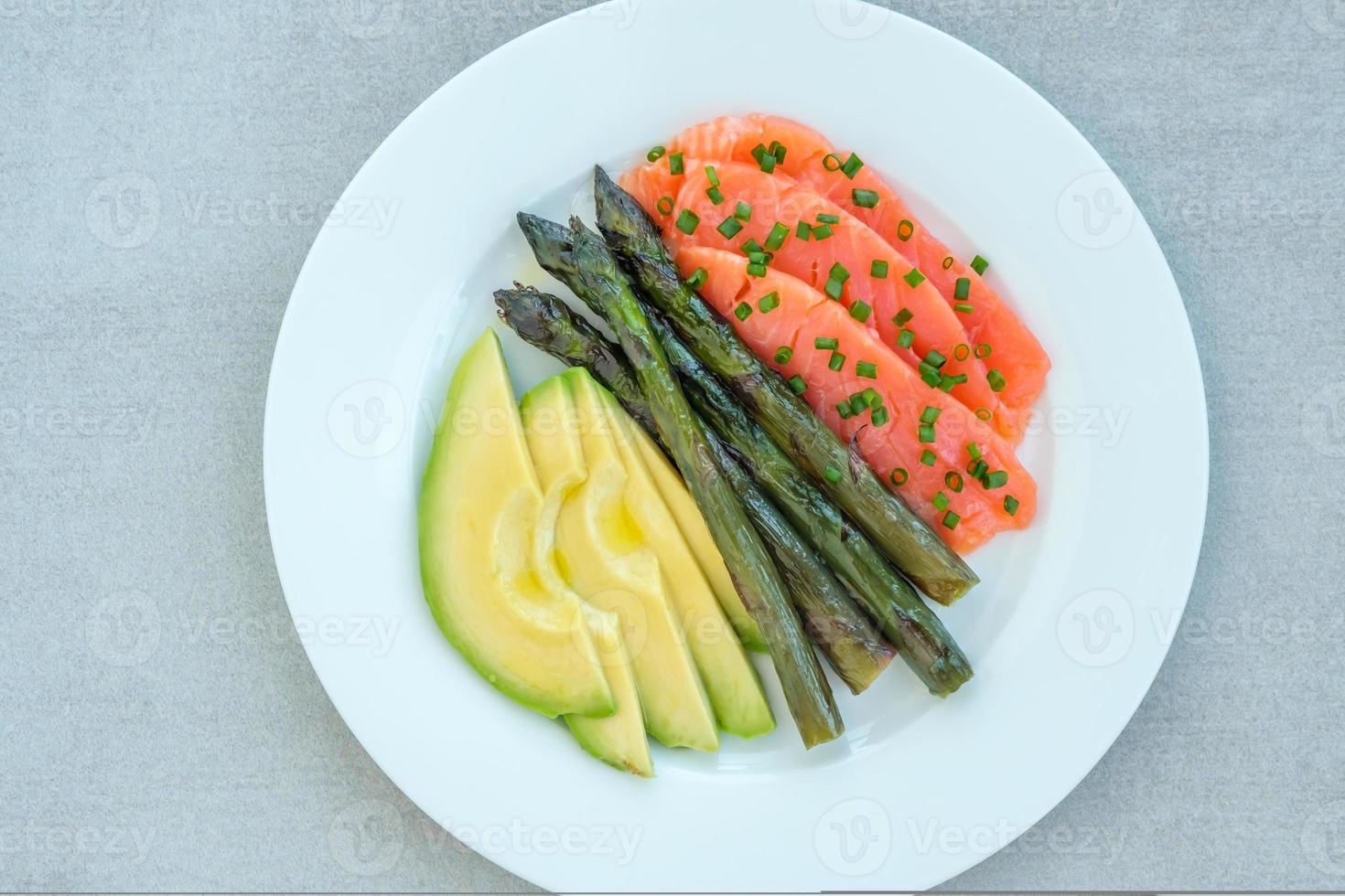 Plato de salmón, aguacate y espárragos foto