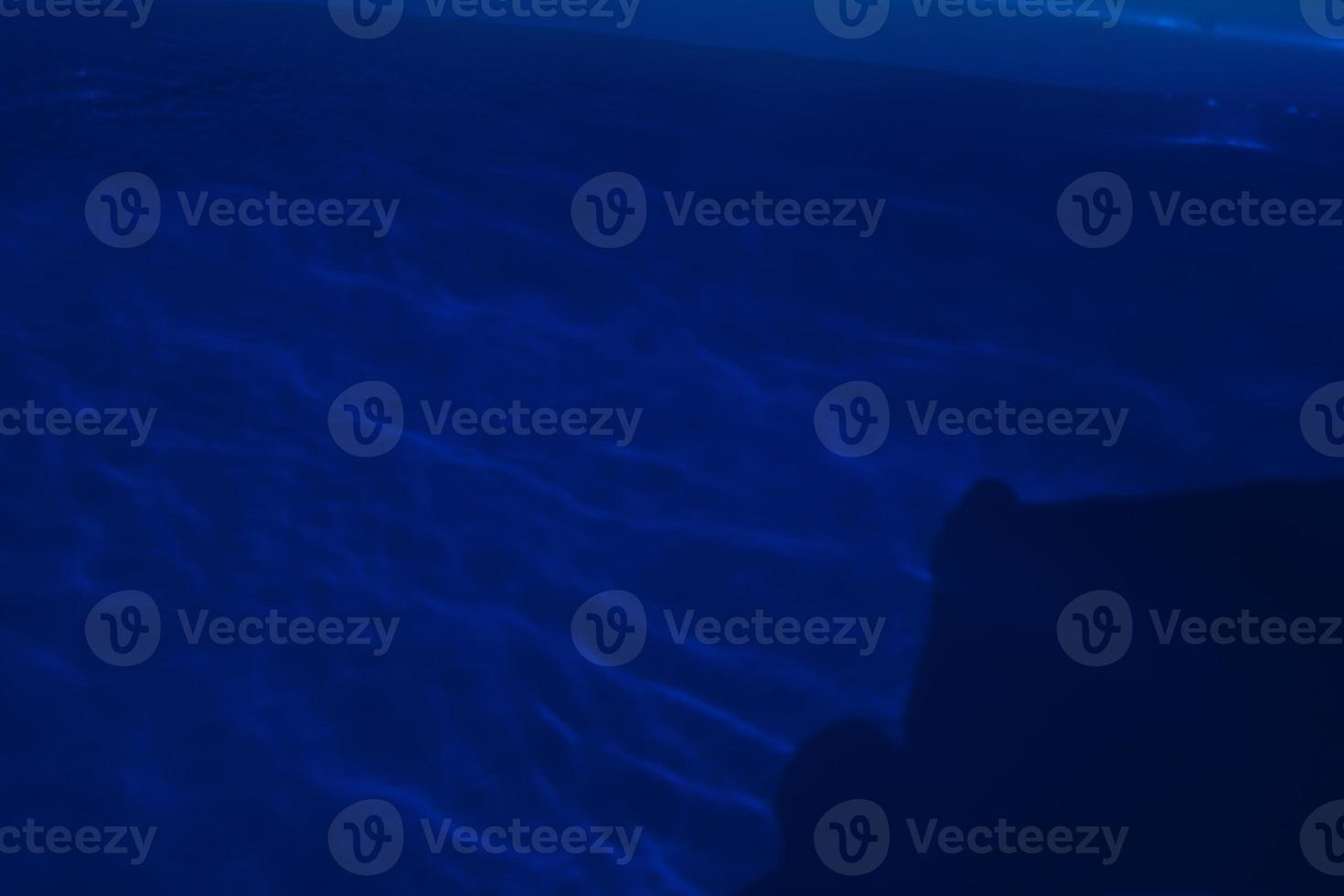 Defocus blurred blue water in swimming pool rippled water detail background. Water surface in the sea, ocean background. Water is an inorganic, transparent, tasteless, odorless, and nearly colorless. photo