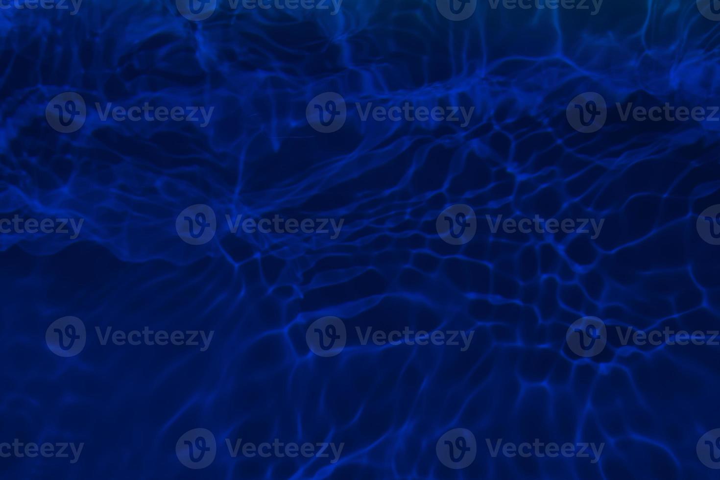 Defocus blurred blue water in swimming pool rippled water detail background. Water surface in the sea, ocean background. Water is an inorganic, transparent, tasteless, odorless, and nearly colorless. photo