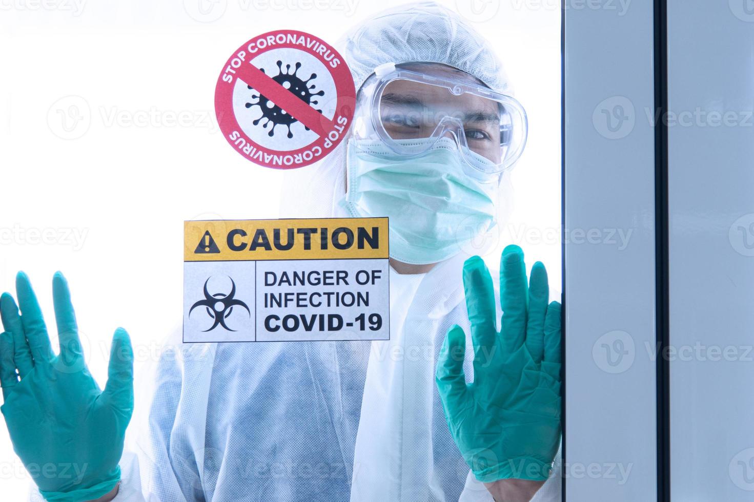 COVID-19, Corona Virus outbreak quarantine epidemic spread and social distancing concept. Asian doctors wear PPE  with CORONA or COVID-19 patient infection in the hospital quarantine room photo