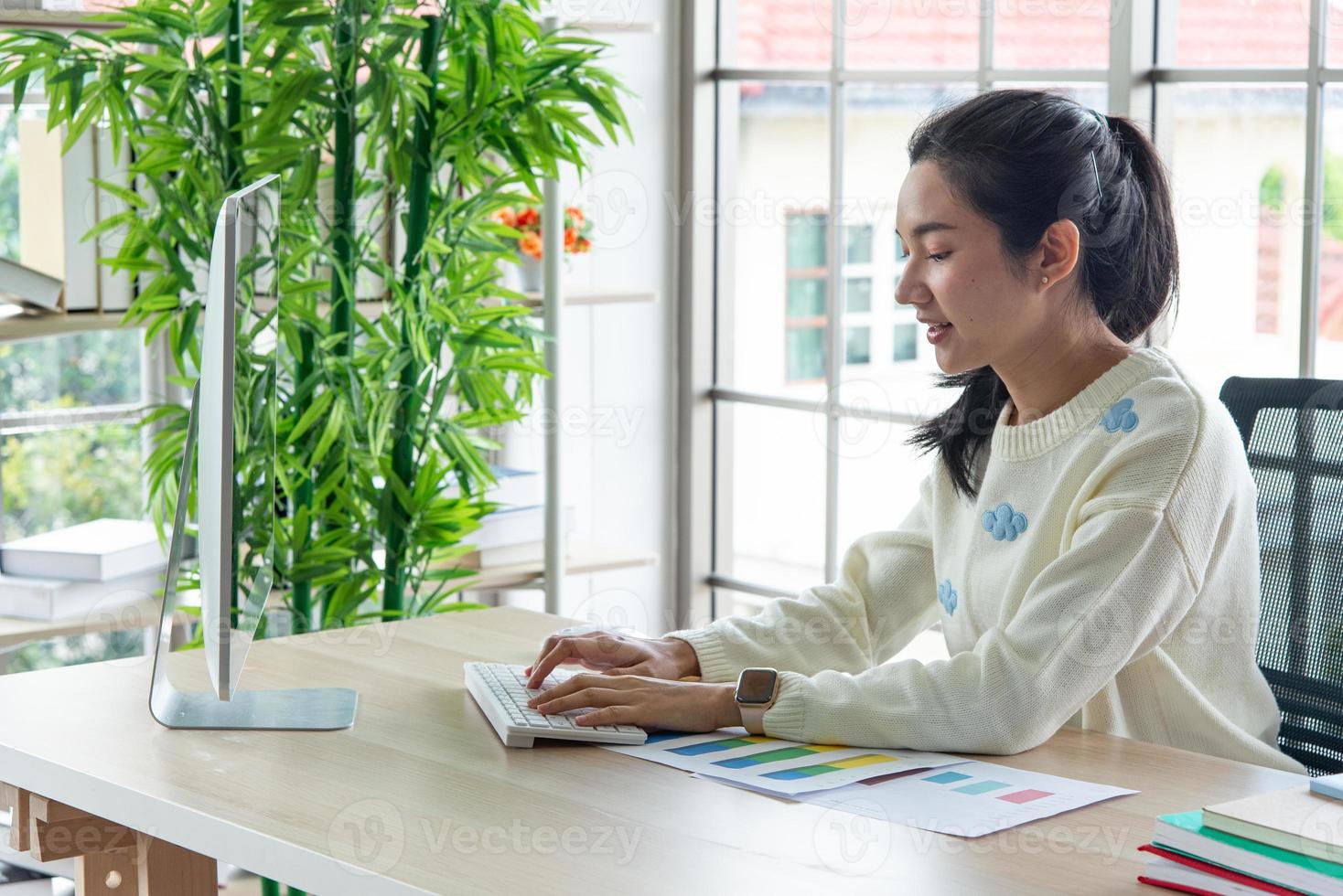 Work from home and online learning concept. Pretty young women working on computer look at the screen in the living room or co-working space. Student study online training course. photo