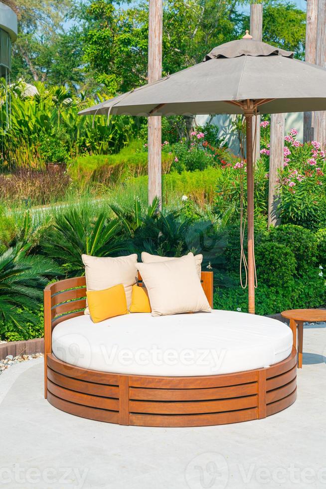 pillows on outdoor patio chair with umbrella photo