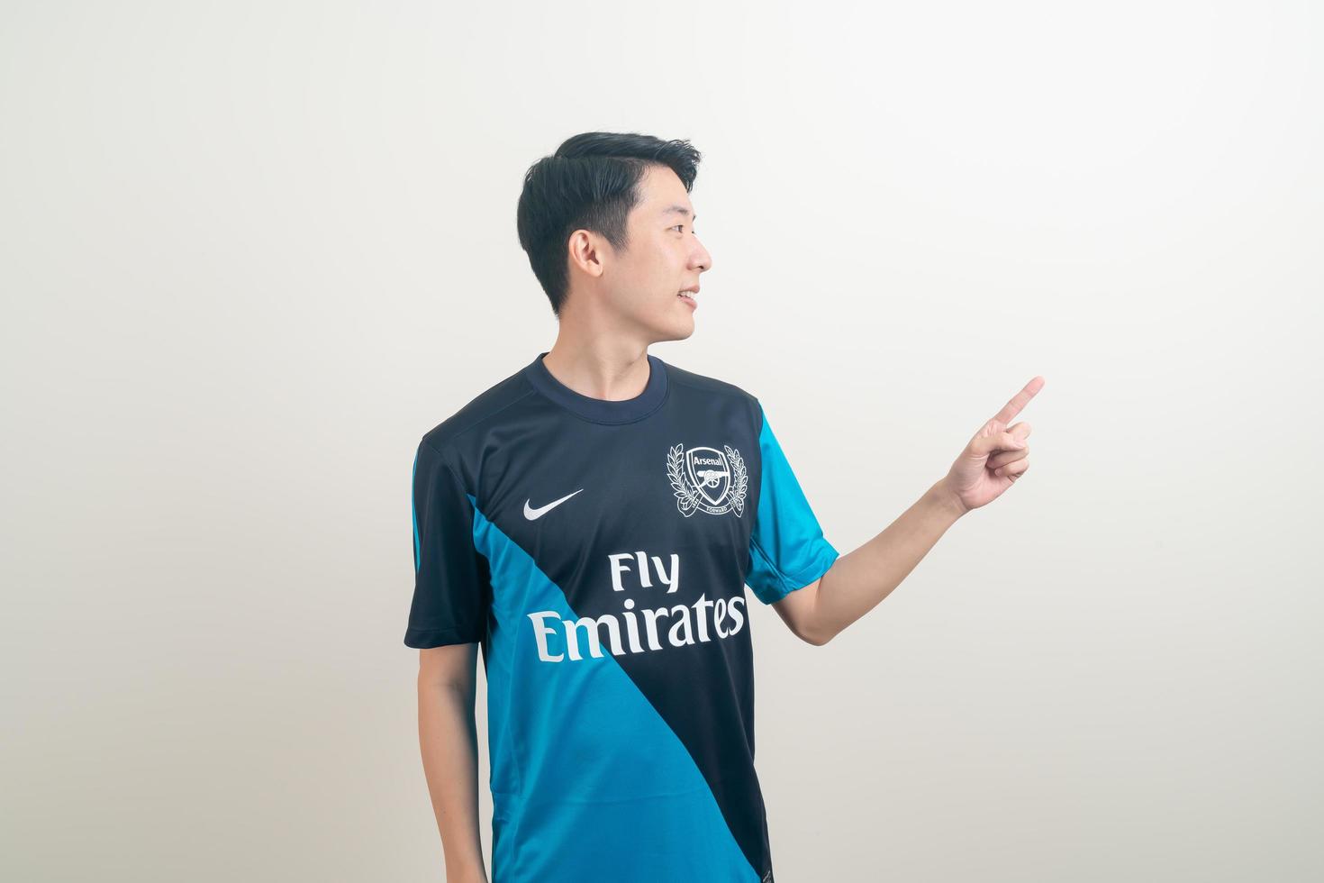 Bangkok, THAILAND - Nov 27, 2021 - Young Asian man wearing Arsenal shirt with white background. photo