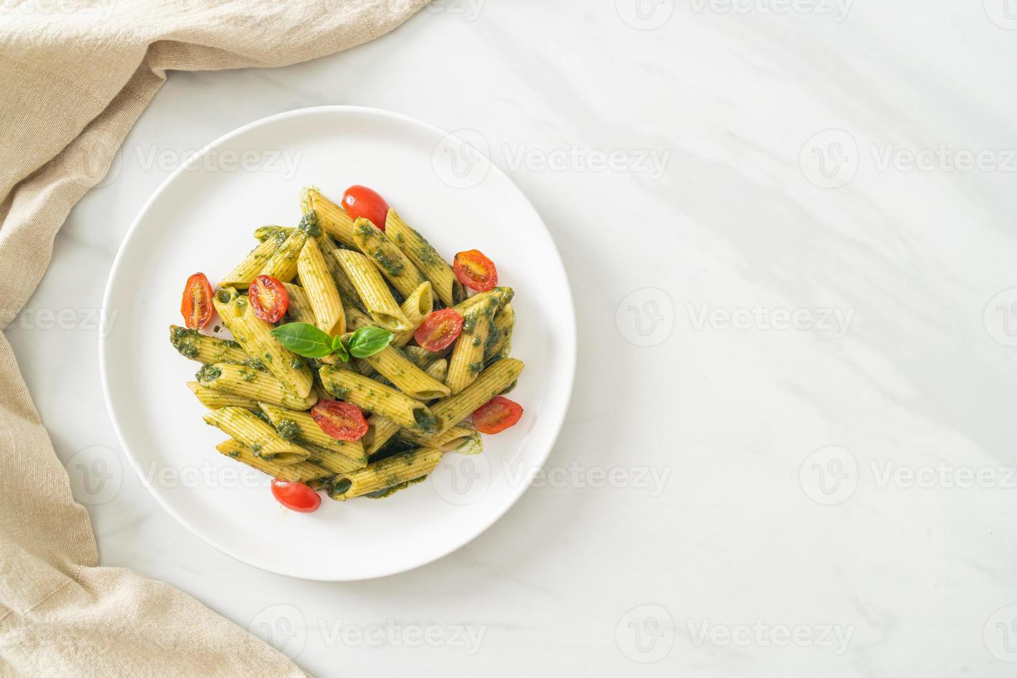 penne pasta with pesto sauce and tomatoes photo