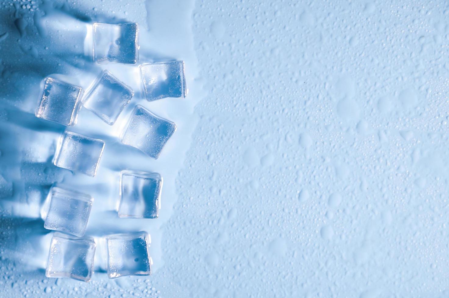 cubitos de hielo sobre fondo azul de estudio. el concepto de frescura con frialdad de cubitos de hielo. foto