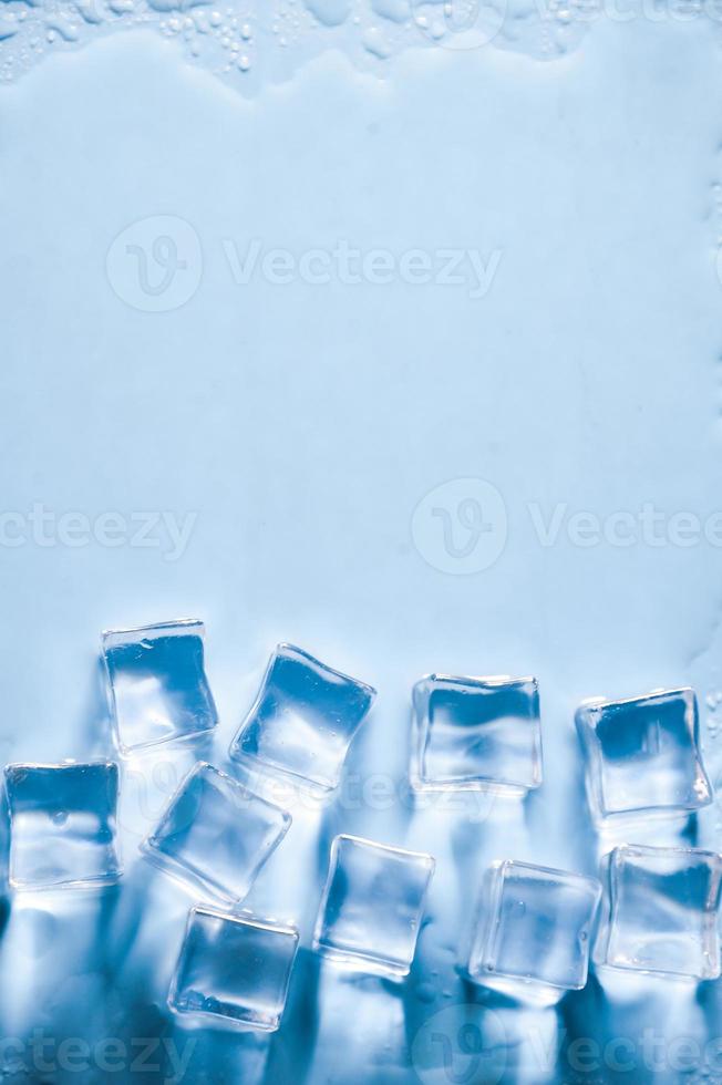 cubitos de hielo sobre fondo azul de estudio. el concepto de frescura con frialdad de cubitos de hielo. foto