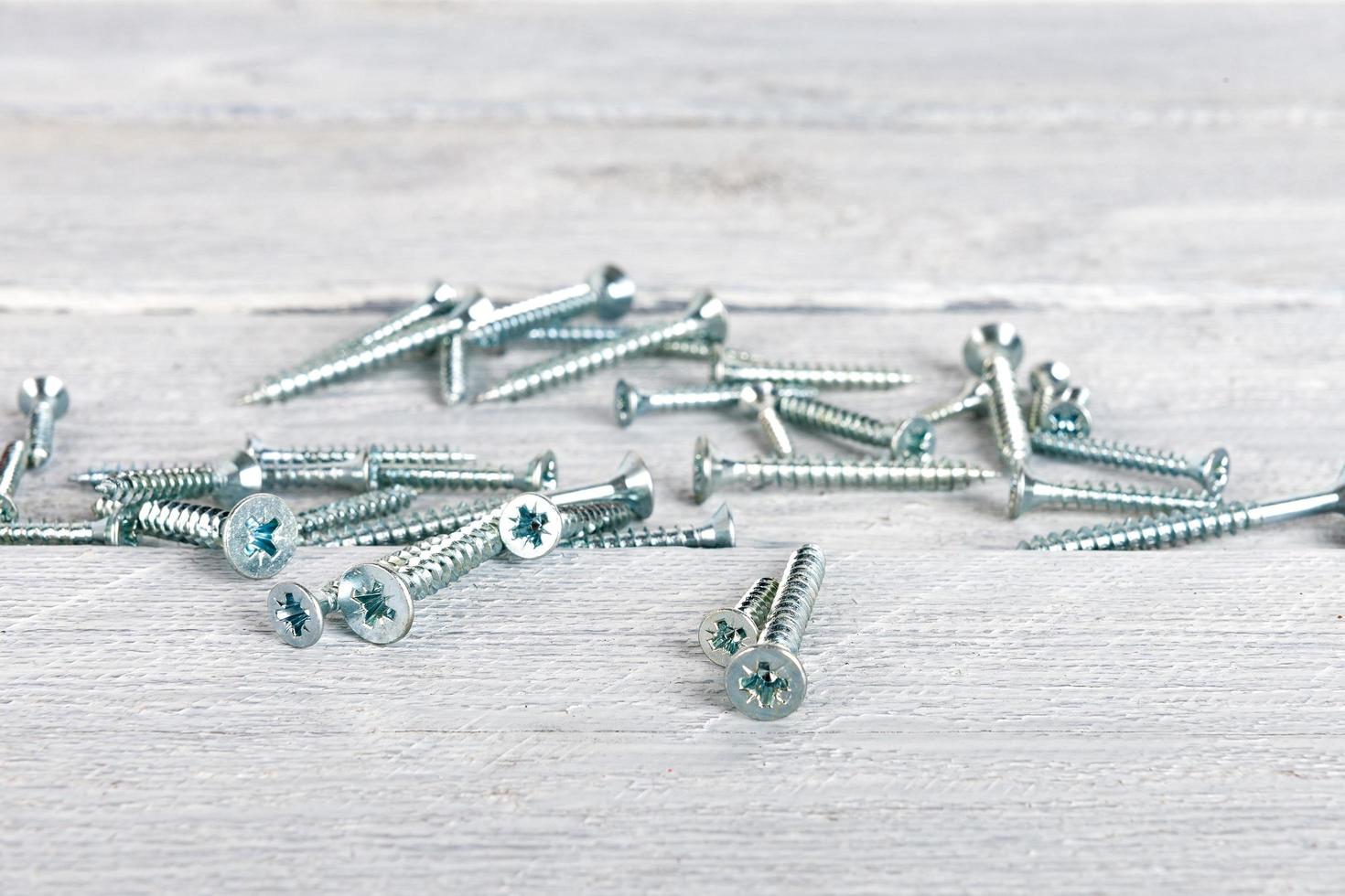Screws on wooden background photo
