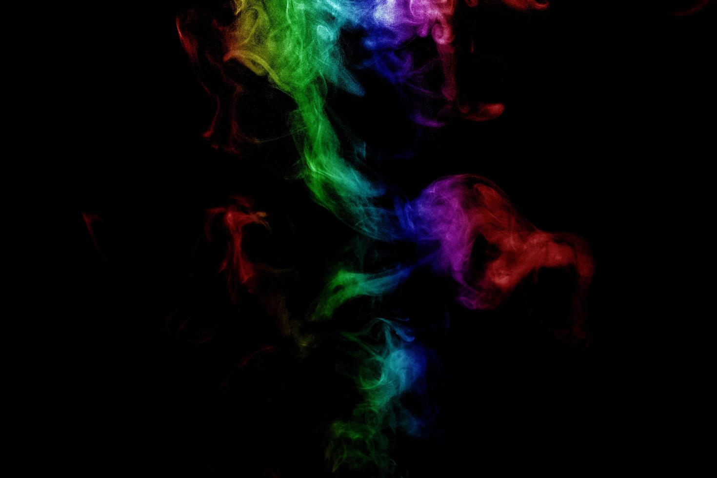 humo abstracto aislado sobre fondo negro, polvo de arco iris foto