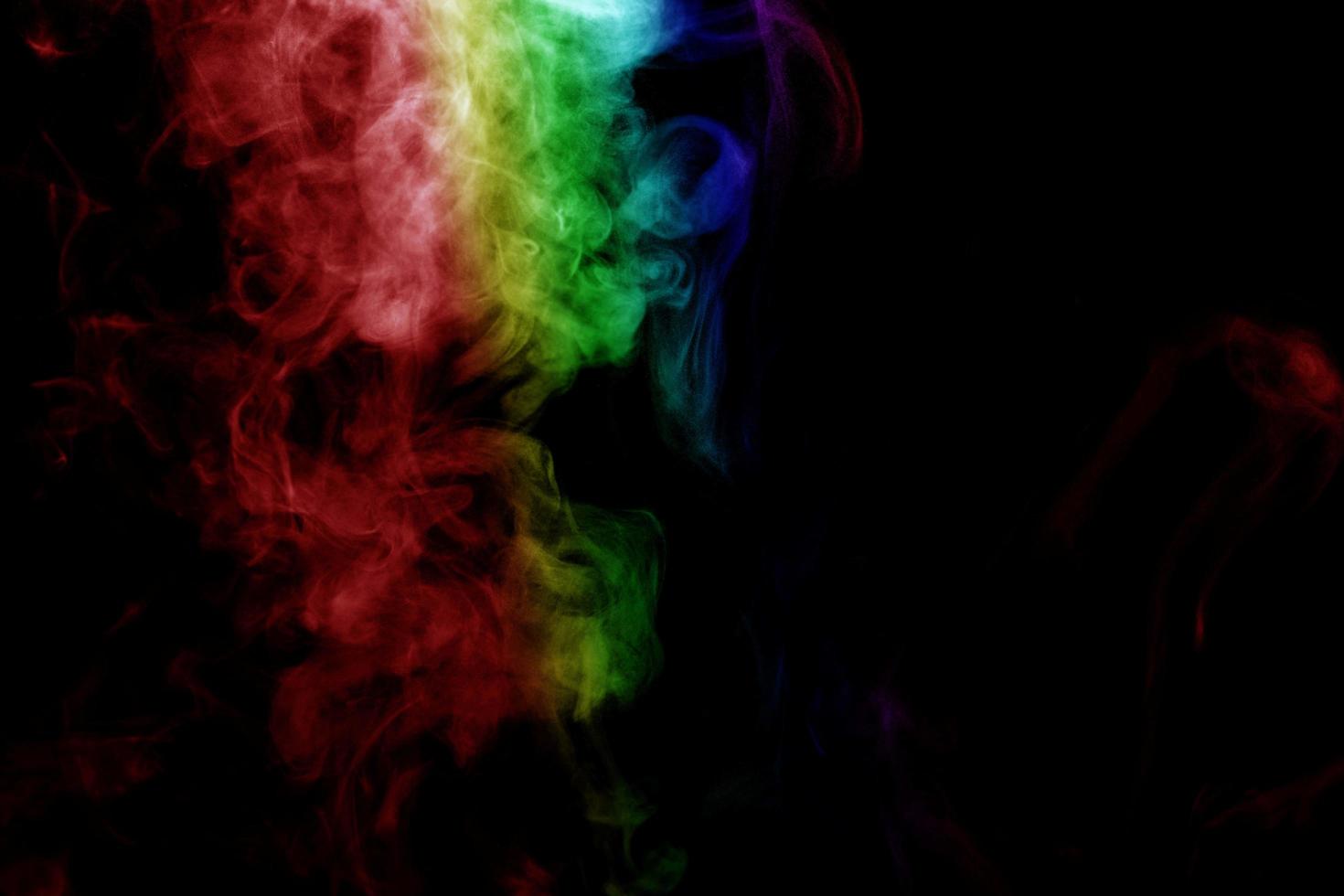 humo abstracto aislado sobre fondo negro, polvo de arco iris foto