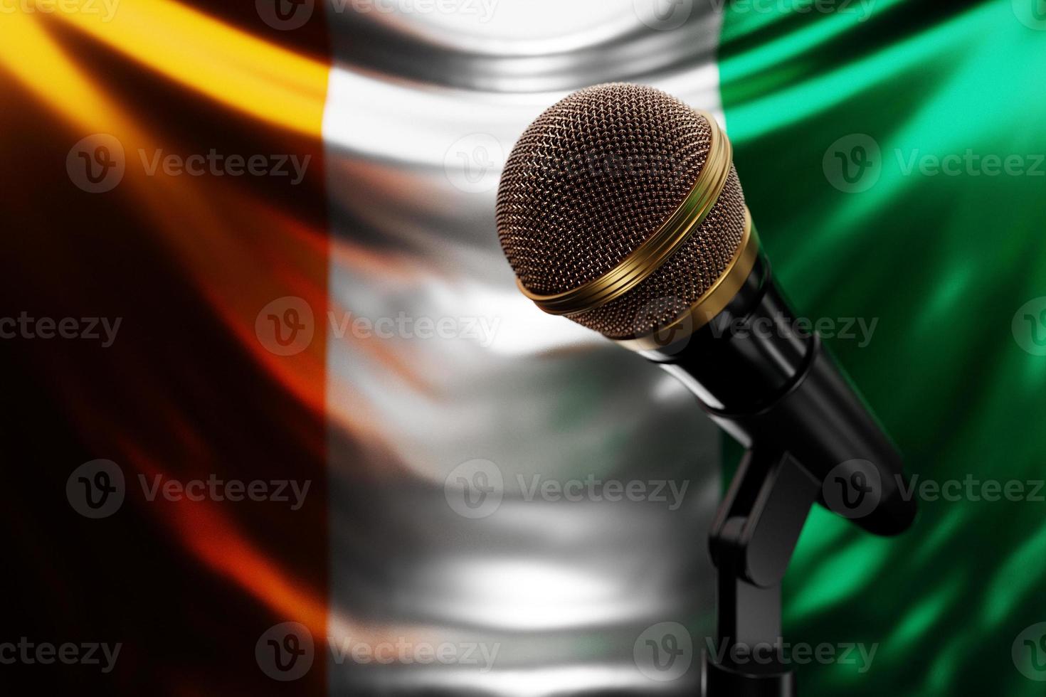 Microphone on the background of the National Flag of Cote d'ivoire, realistic 3d illustration. music award, karaoke, radio and recording studio sound equipment photo