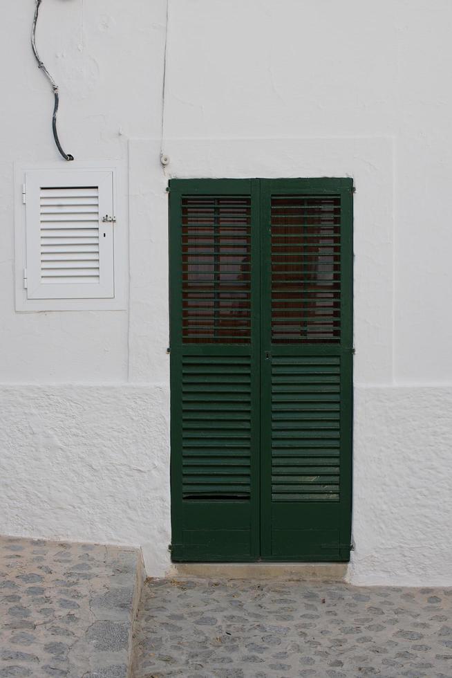 Green door in white building photo