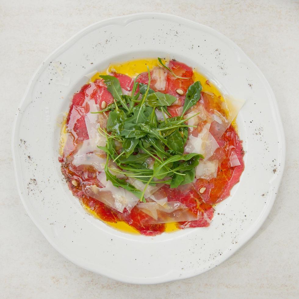 Delicious carpaccio with parmesan and arugula photo