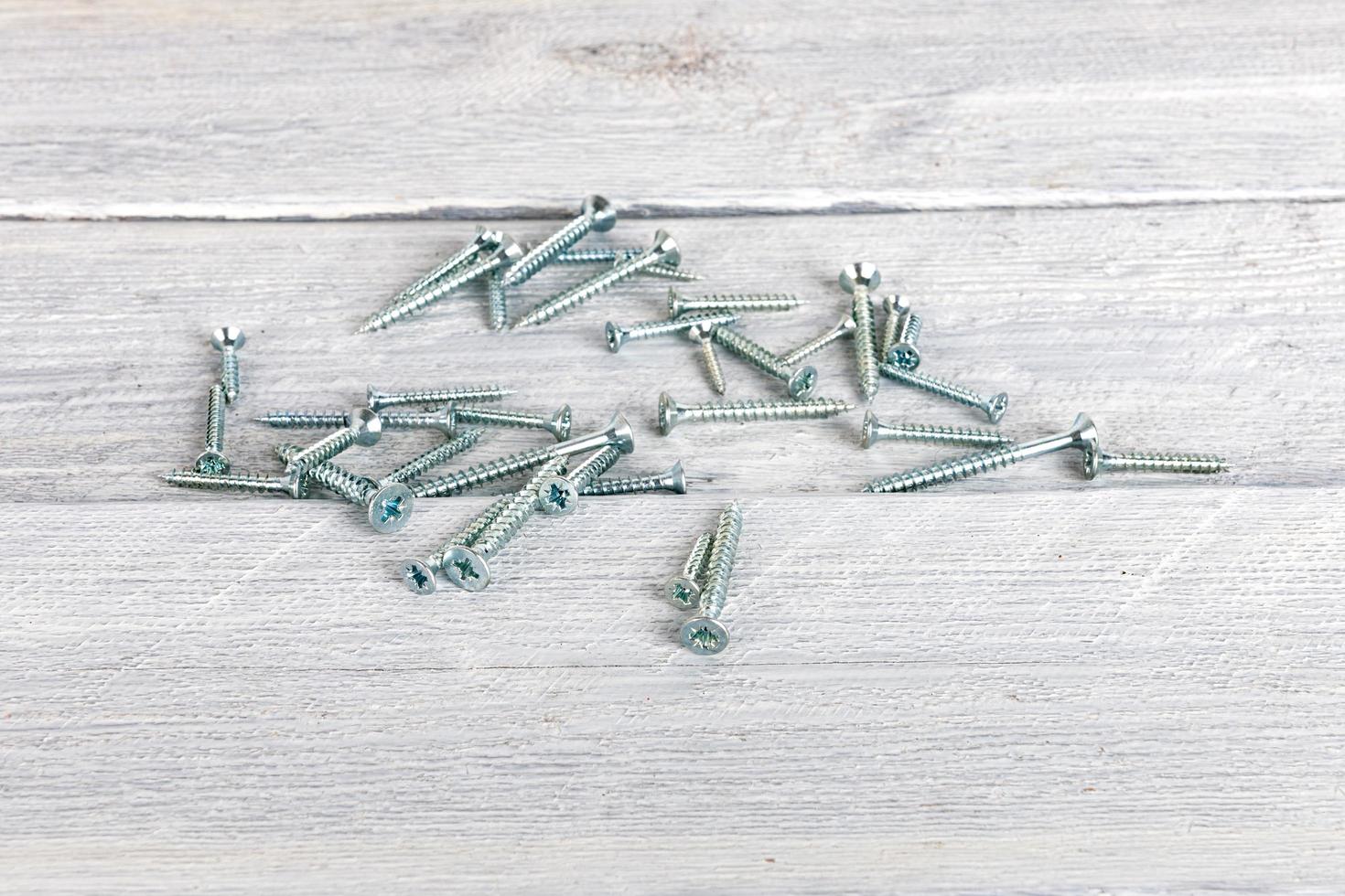 Screws on wooden background photo