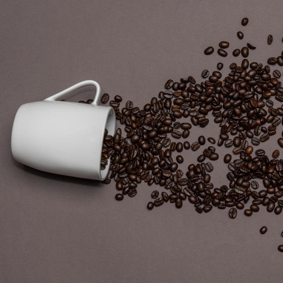 Coffee beans and white cup on coloured background photo