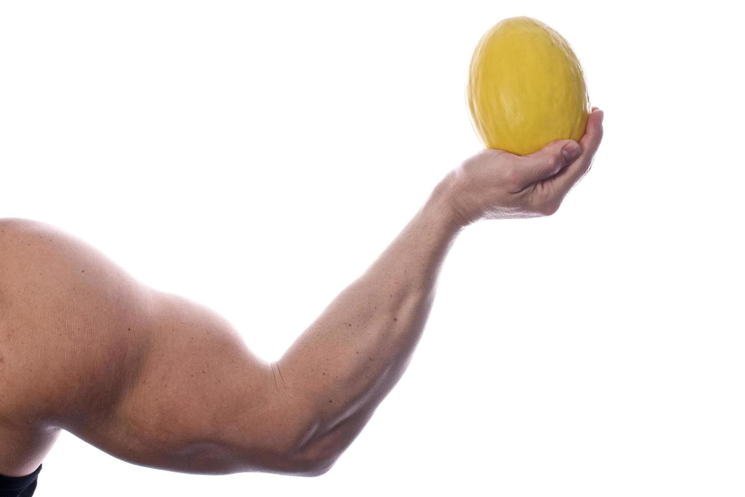 Muscular man holding vegetables and fruit photo