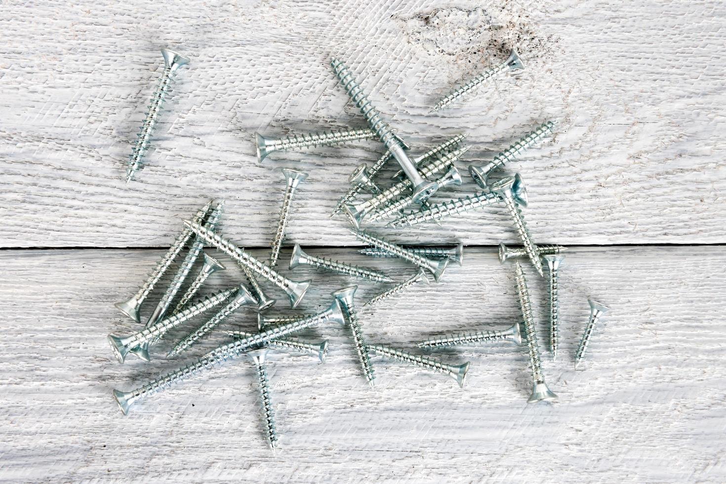 Screws on wooden background photo
