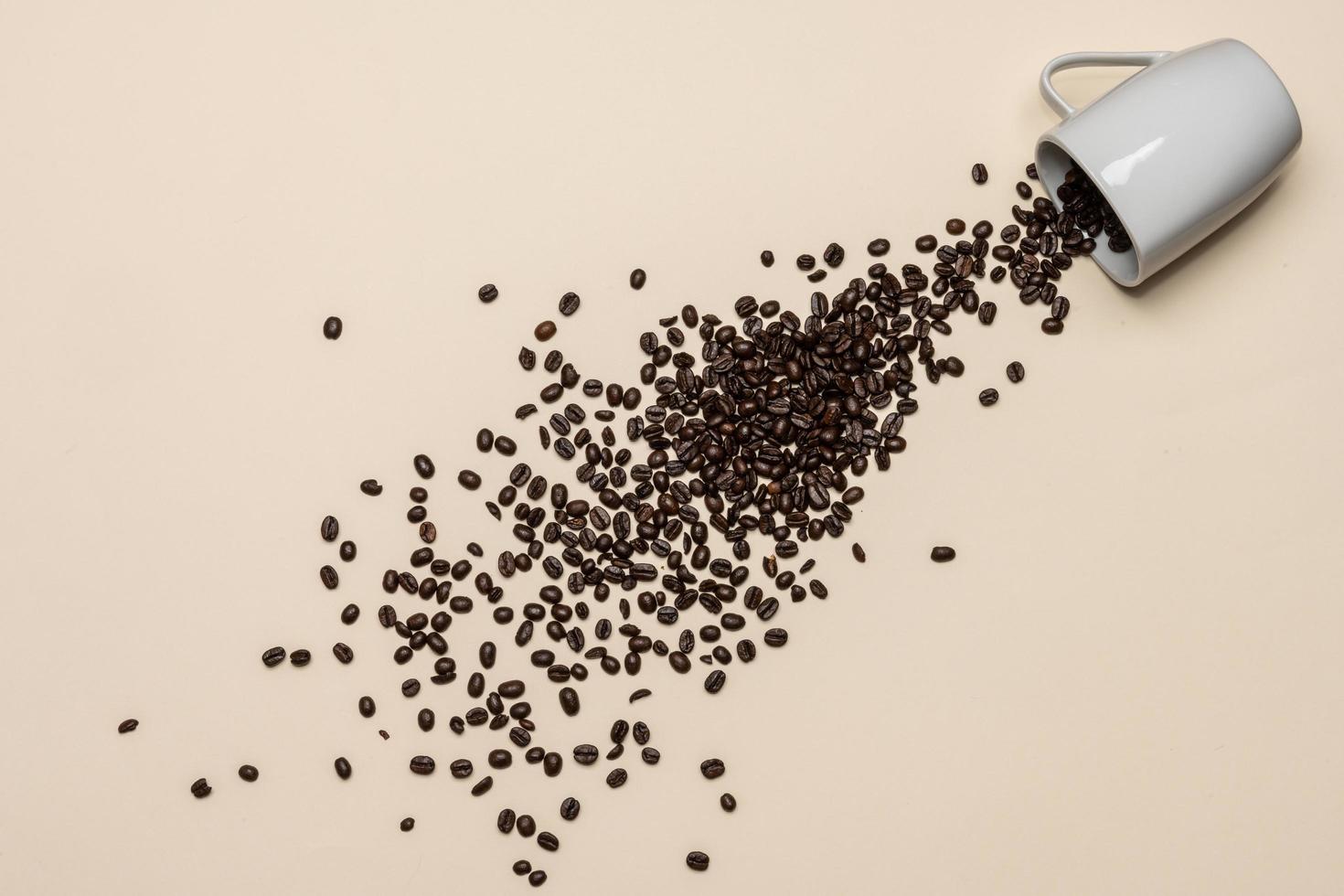 Coffee beans and white cup on coloured background photo