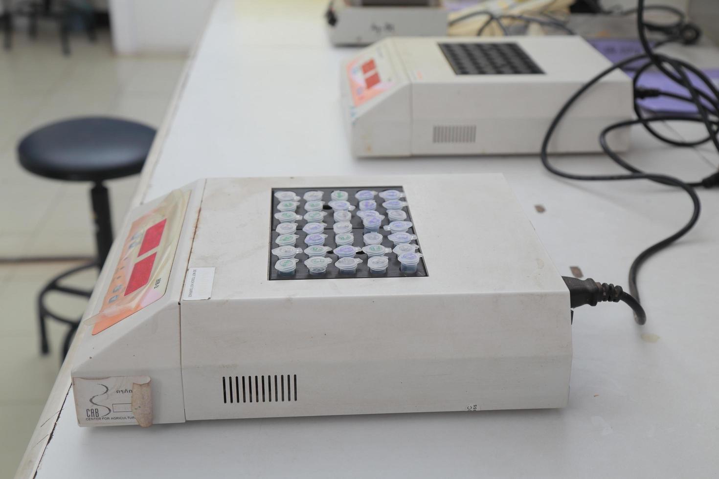 mujer científica bioquímica en el lugar de trabajo hace el análisis en el laboratorio moderno. ella está sosteniendo un gotero y un tubo de ensayo foto