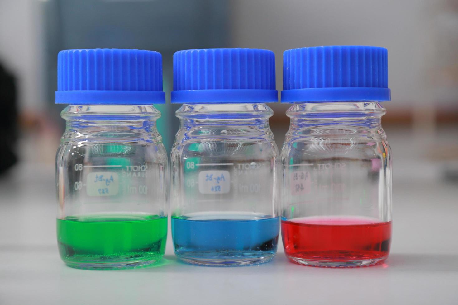Woman scientist biochemist at the workplace makes the analysis in the modern laboratory. She is holding a dropper and a test tube photo