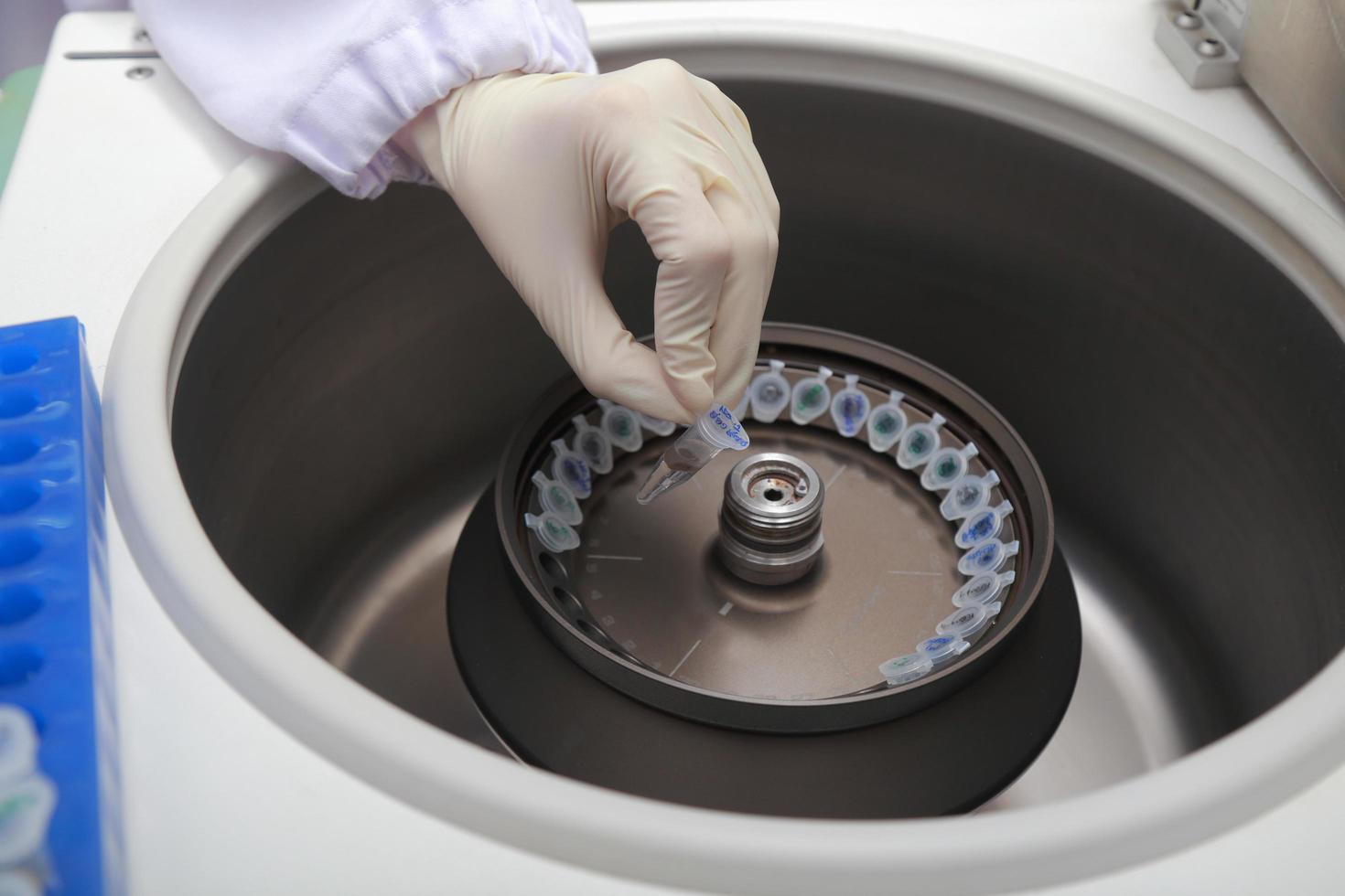 Scientist loading a sample to centrifuge photo