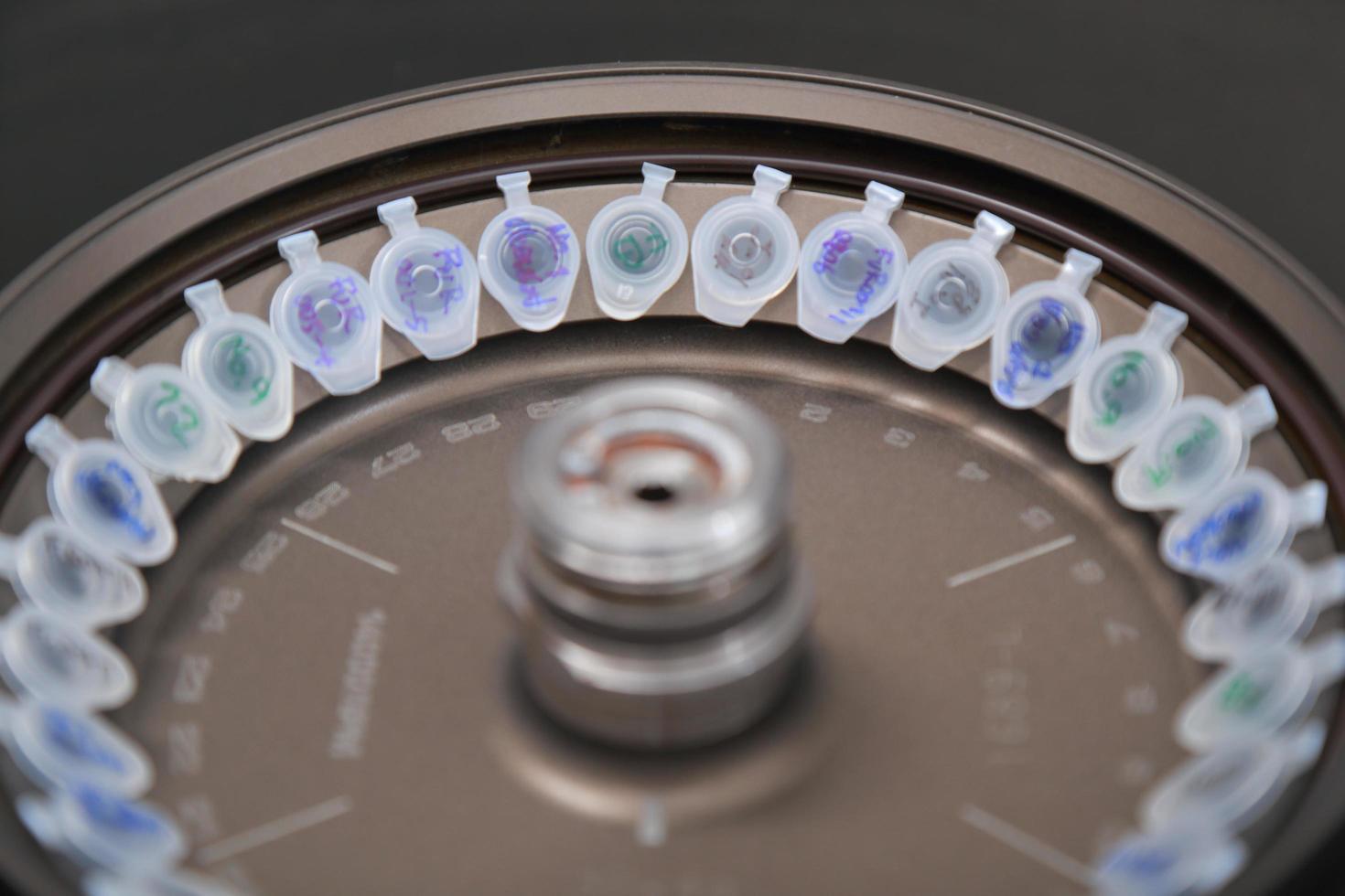 Scientist loading a sample to centrifuge photo