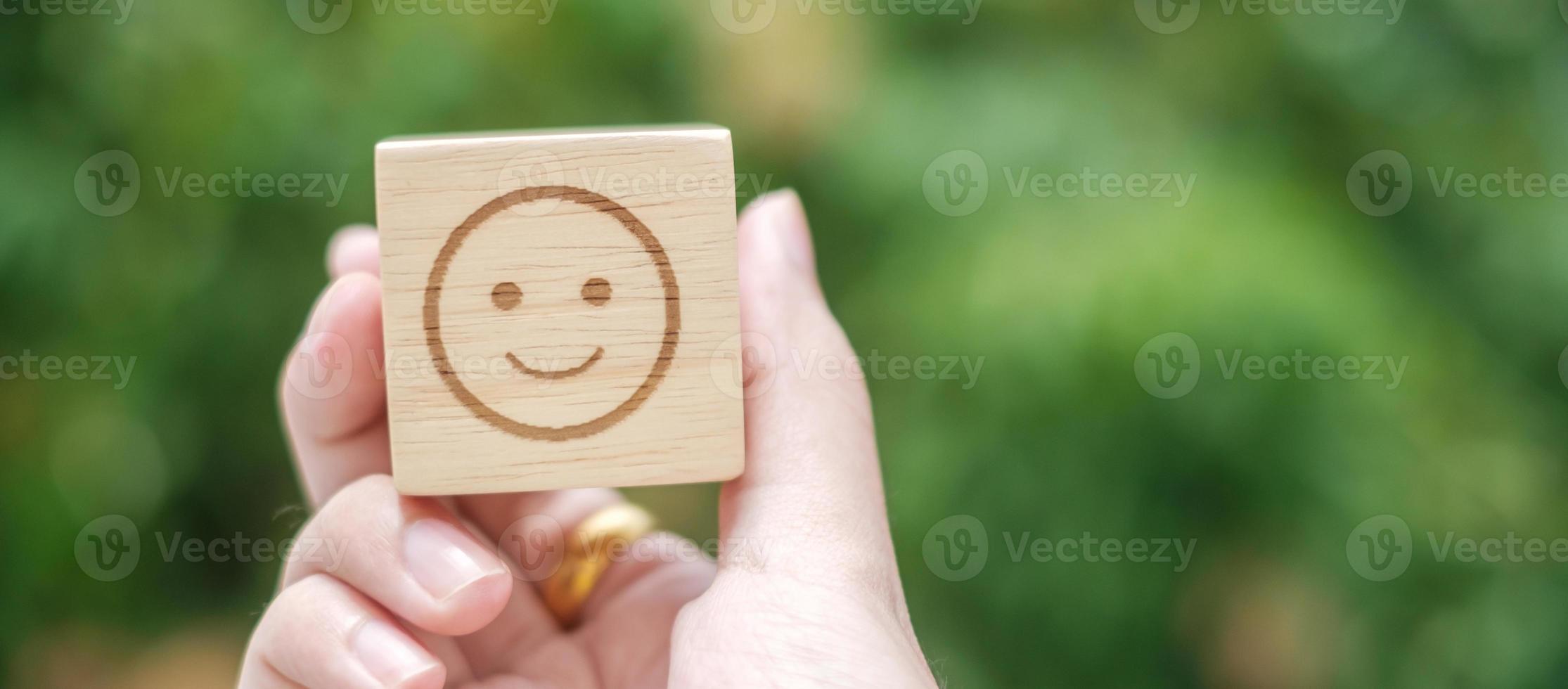 Smile emotion face symbol on wooden blocks. Service rating, ranking, customer review, satisfaction, evaluation and feedback concept photo