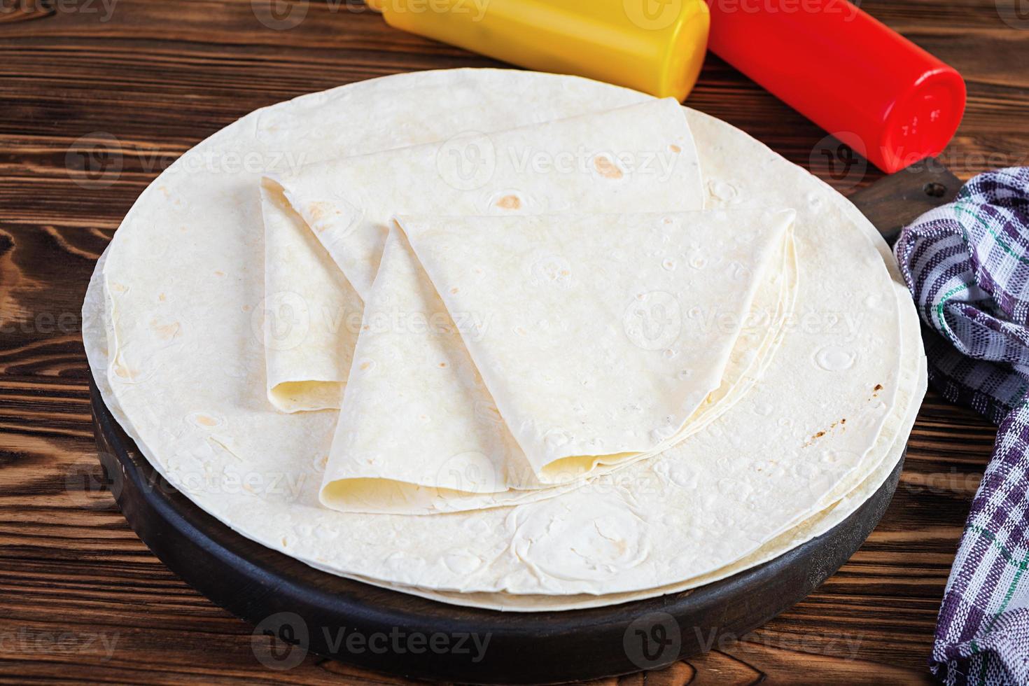 Round lavash on a wooden background. Isolated pita bread photo
