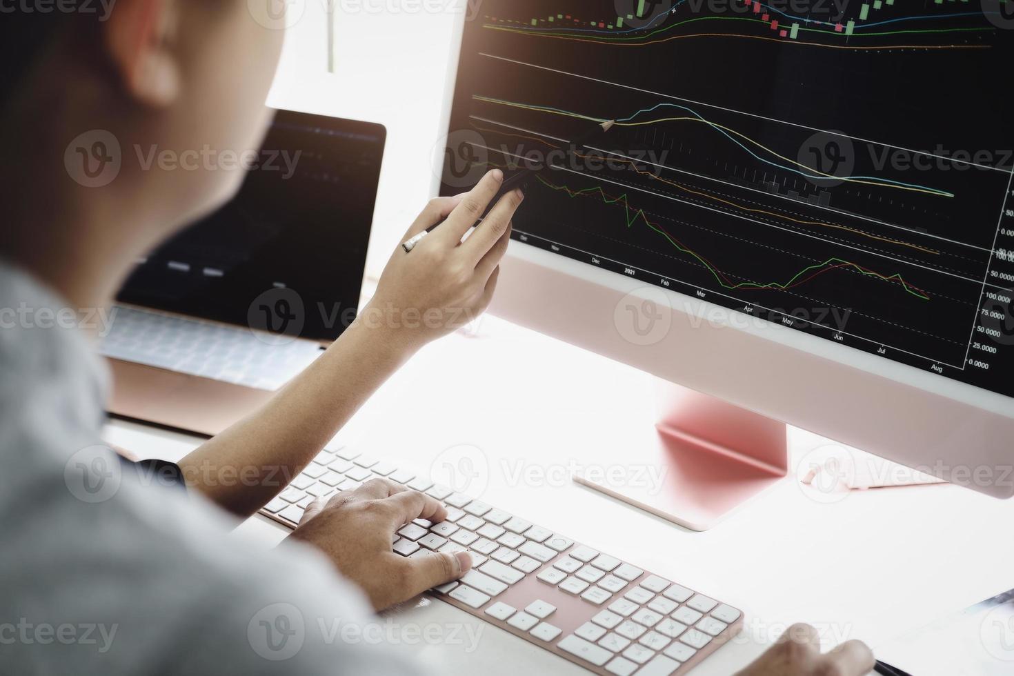 An investment expert points a pen at a tablet monitor to analyze the stock market to teach you how to make a profit. photo