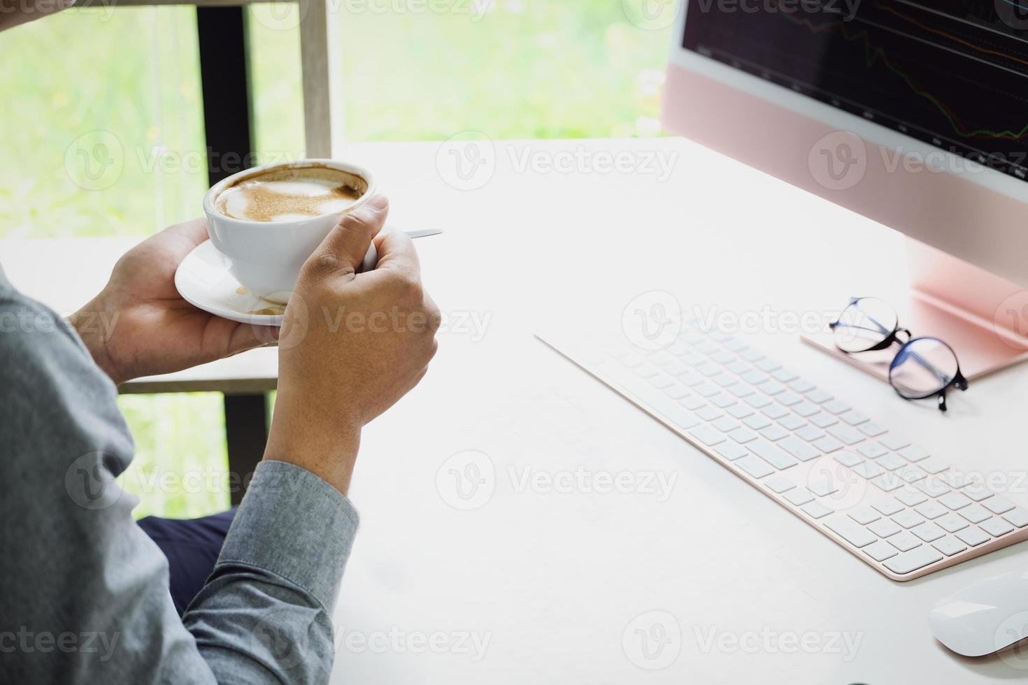 Work from home A company employee holding a coffee cup using a computer to work from home to prevent coronavirus from meeting outsiders. photo